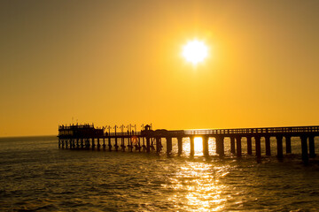 Fototapeta na wymiar Pier or jetty at sunset / sunrise over sea