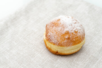 donut in icing sugar ice on a light surface