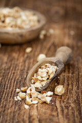 Portion of freshly chopped Hazelnuts (close up; selective focus)