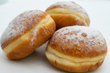 three donuts sprinkled with powdered sugar close-up