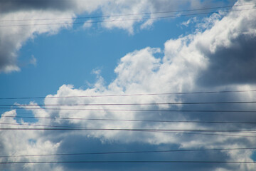 Fluffy clouds cover the summer blue sky