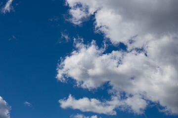 Naklejka na ściany i meble Fluffy clouds cover the summer blue sky