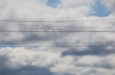 Fluffy clouds cover the summer blue sky