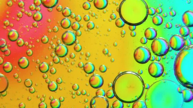 Top view movement of oil bubbles. Oil surface multicolored background. Fantastic structure of colorful bubbles. Abstract colorful background. Closeup bubbles in water.