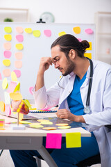 Young male medic in conflicting priorities concept