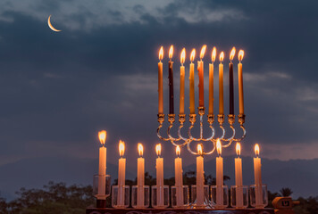 Menorah with light of candles is traditional symbol for Hanukkah Holiday, blurred natural mountain background   © sergei_fish13