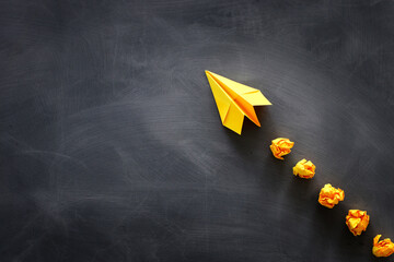 education or innovation concept. paper origami plane over blackboard background