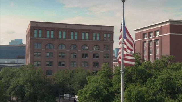 Aerial: USA Flag in Dealey Plaza where President JFK was assassinated. Texas, USA