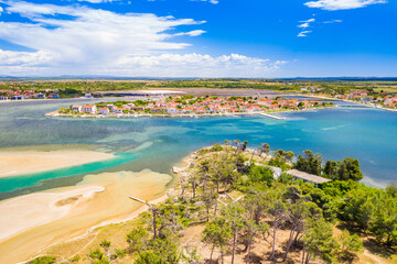Aerial view of town of Nin and lagoon in Dalmatia, Croatia. Coastline and turquoise water and blue sky with clouds.
