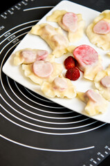 Plate of Polish strawberry dumplings in the kitchen.