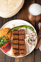 Turkish Adana Kebap With Rice Pilaf And Vegetables Served On A Plate