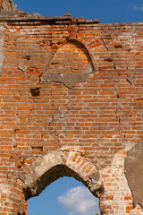 The ruined gothic vault of the old catholic chapel. The ruins of an old church. Brick wall and blue sky.