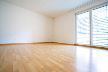 view of a very bright and light bedroom with wooden parquet flooring and white plaster walls