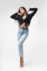 Young cool hipster girl in black shirt and blue banana jeans on white background