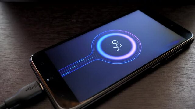 displaying 99 percent of the battery power of a mobile phone. mobile phone on a wooden table