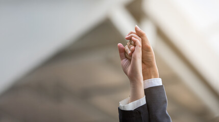 Businessman and businesswoman hold hands high up in the air. Business success concept with copy...