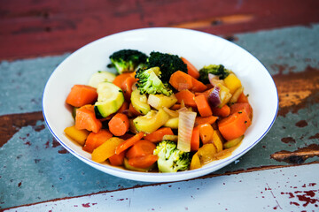 close-up of white plate with mixed vegetables on wooden table