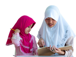 Muslim young woman teaching, explaining to adorable muslim girl what's in the book. Home school, education, Tution concept.