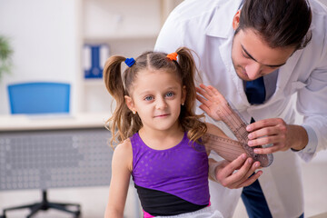 Small girl visiting young male doctor