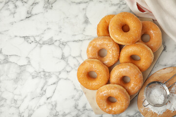 Delicious donuts on marble table, flat lay. Space for text