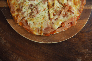 Delicious fresh prepared pizza on the wooden background.
