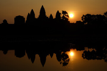 Fototapeta na wymiar Silhouette of the temple Angkor wat and its reflection in the lake at sunrise
