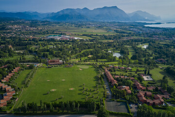 Fototapeta na wymiar Panoramic aerial view of the famous gardagolf country club located not far from Lake Garda Italy. In the background mountains