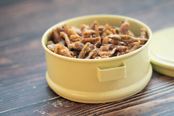 Fried crispy small fish put in tiffin carrier. Thai style appetizer or snack