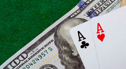 Two aces on a green background and a hundred dollar bill