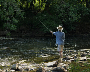 A fisherman casts his line over the River Aire at Hirst Wood hoping to catch a fish in the fast moving waters