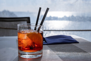 A Negroni -- the iconic Italian cocktail, made of one part gin, one part vermouth rosso, and one part Campari, garnished with orange peel -- served on the Italian coast. 