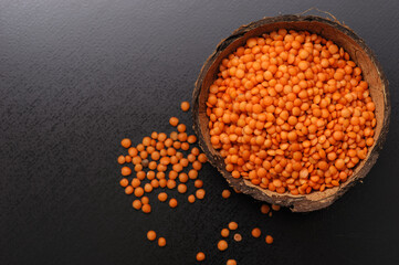 red dry lentils in a bowl on a gray dark background