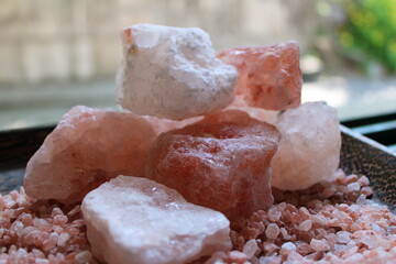 Himalayan pink salt in rock form on pink salt granules