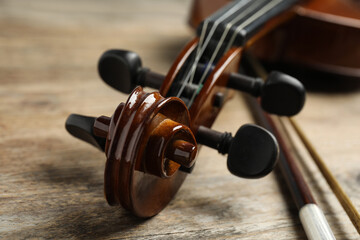 Beautiful violin and bow on wooden table, closeup