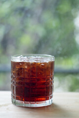 A glass of iced black coffee in glass on the table