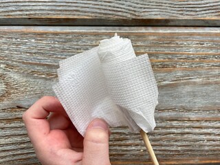 Step by step process of making a flower from a napkin.