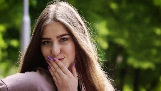 Beautiful atractive young girl looking at camera at sunny park. Flirt and seduction concept