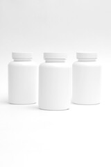 three white plastic containers for pills for healthy food in a row are isolated on white background