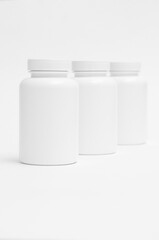 three white plastic containers for pills for healthy food one by one isolated on white background