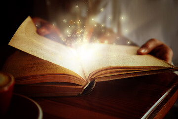 Obraz na płótnie Canvas Woman reading shiny magic book, closeup view