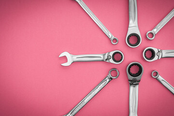 Repair tool. Metal wrenches on a pink background.