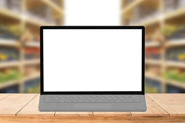 laptop or notebook with blank copy space for your text on wooden mock up over blurred supermarket  background for advertisement showcase or 
 advertising marketing concept. 
