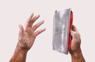 Dusty hands of a worker and a tool for grinding putty. Sanding putty. Male hands stained with...