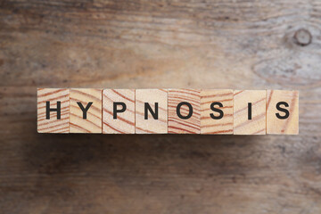 Fototapeta premium Blocks with word HYPNOSIS on wooden background, flat lay