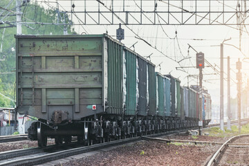 Fototapeta na wymiar Freight train moves on the station at sunset time.