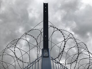 Barbed wire in dark clouds
