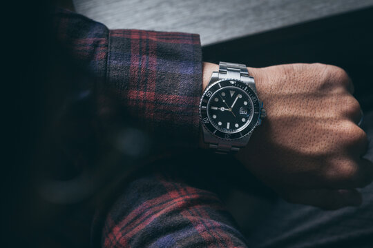 fashionable wearing stylish looking at luxury watch on hand check the time at workplace.concept for managing time organization working,punctuality,appointment