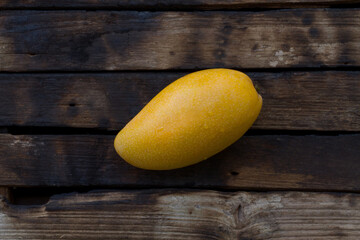 Ripe yellow mango on dark color of wood background