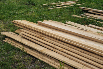 Stack of natural wooden boards on building site. Industrial timber for carpentry, building or repairing, lumber material for roofing construction.