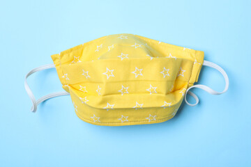 Homemade protective mask on light blue background, top view. Sewing idea - Powered by Adobe